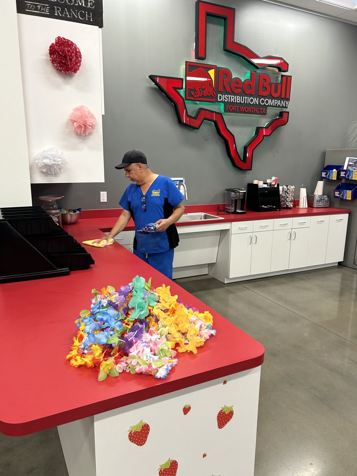 Tamez crew member cleaning a client break room counter for Red Bull Distribution Company
